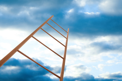 Image of Wooden ladder against blue sky with clouds, low angle view