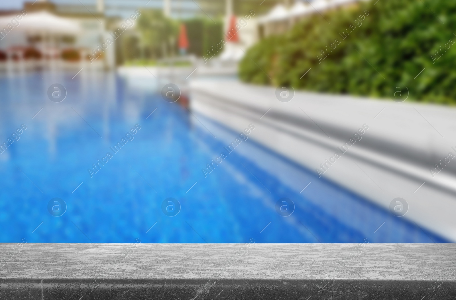 Image of Grey stone deck near swimming pool outdoors on sunny day. Space for text