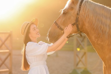 Photo of Woman with adorable horse outdoors on sunny day. Lovely domesticated pet