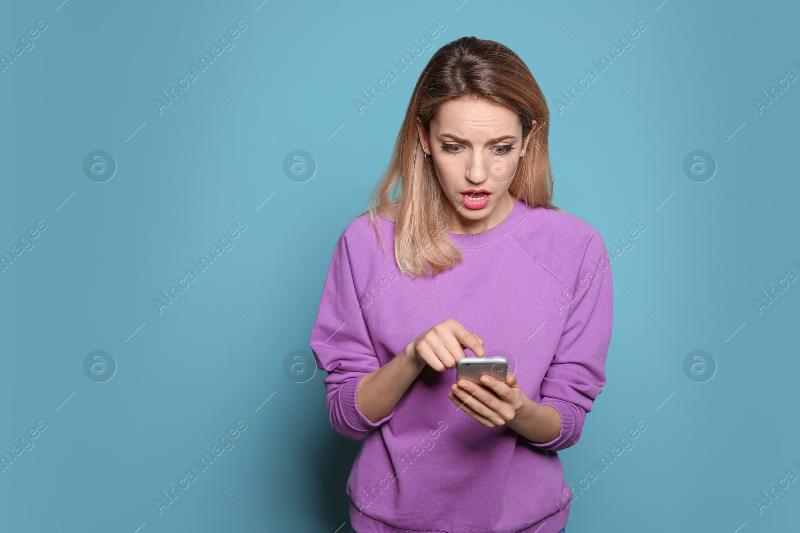 Photo of Young woman using phone on color background