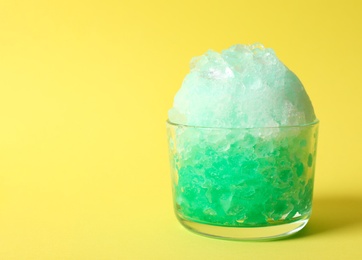 Photo of Shaving ice in glass dessert bowl on yellow  background, closeup. Space for text