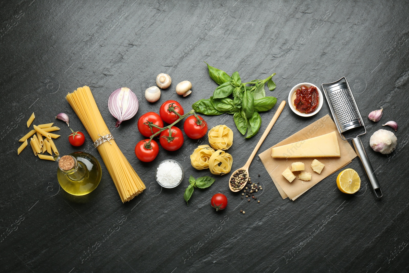 Photo of Different types of pasta, spices, garter and products on dark textured table, flat lay