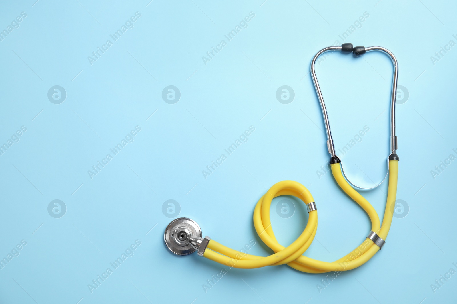 Photo of Stethoscope with space for text on color background, top view. Medical tool