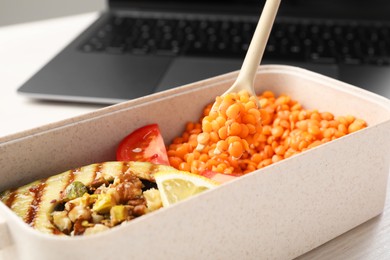 Healthy products high in vegetable fats near laptop on light table, closeup