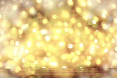 Blurred view of gold lights as abstract background, bokeh effect