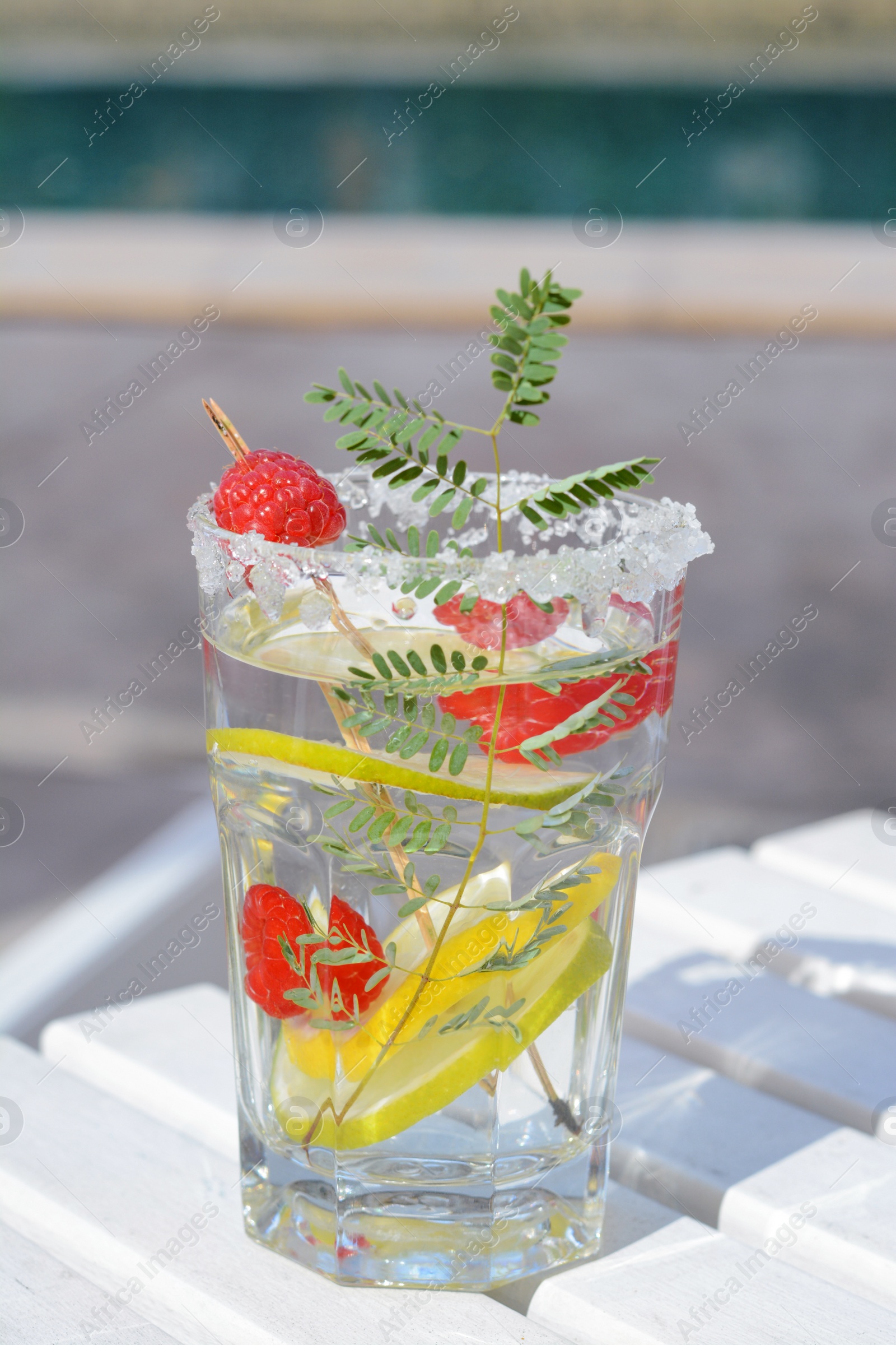 Photo of Delicious refreshing lemonade on white wooden table outdoors