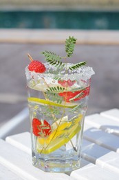 Photo of Delicious refreshing lemonade on white wooden table outdoors