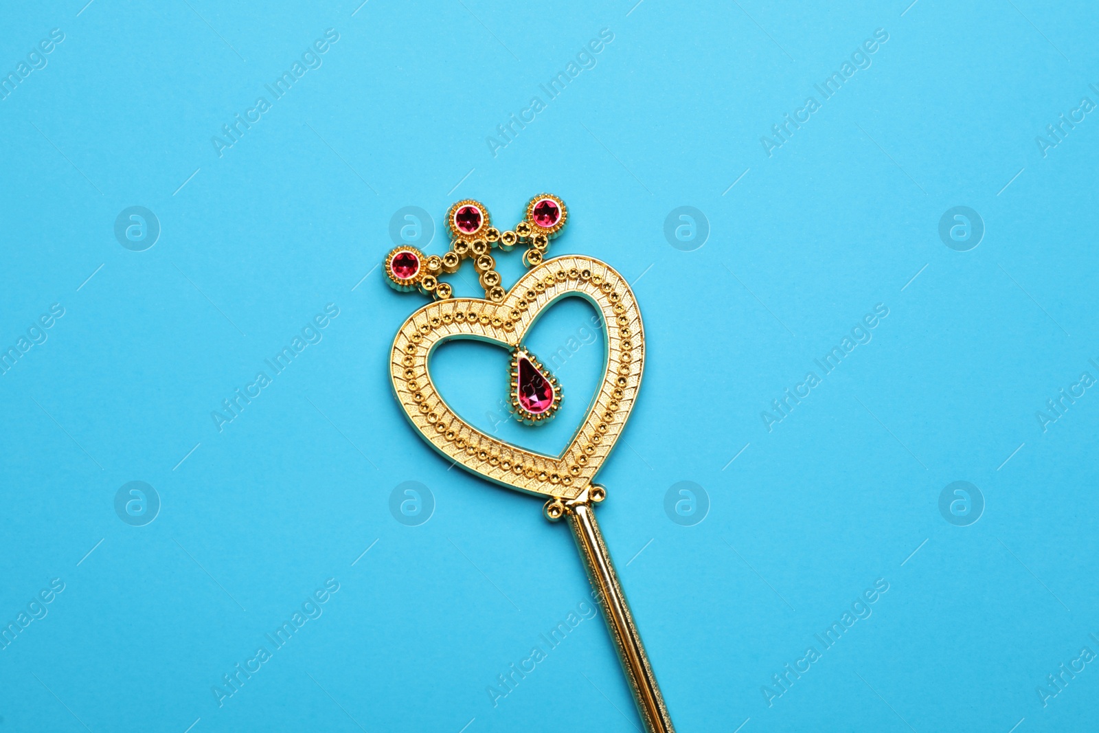 Photo of Beautiful golden magic wand on light blue background, top view