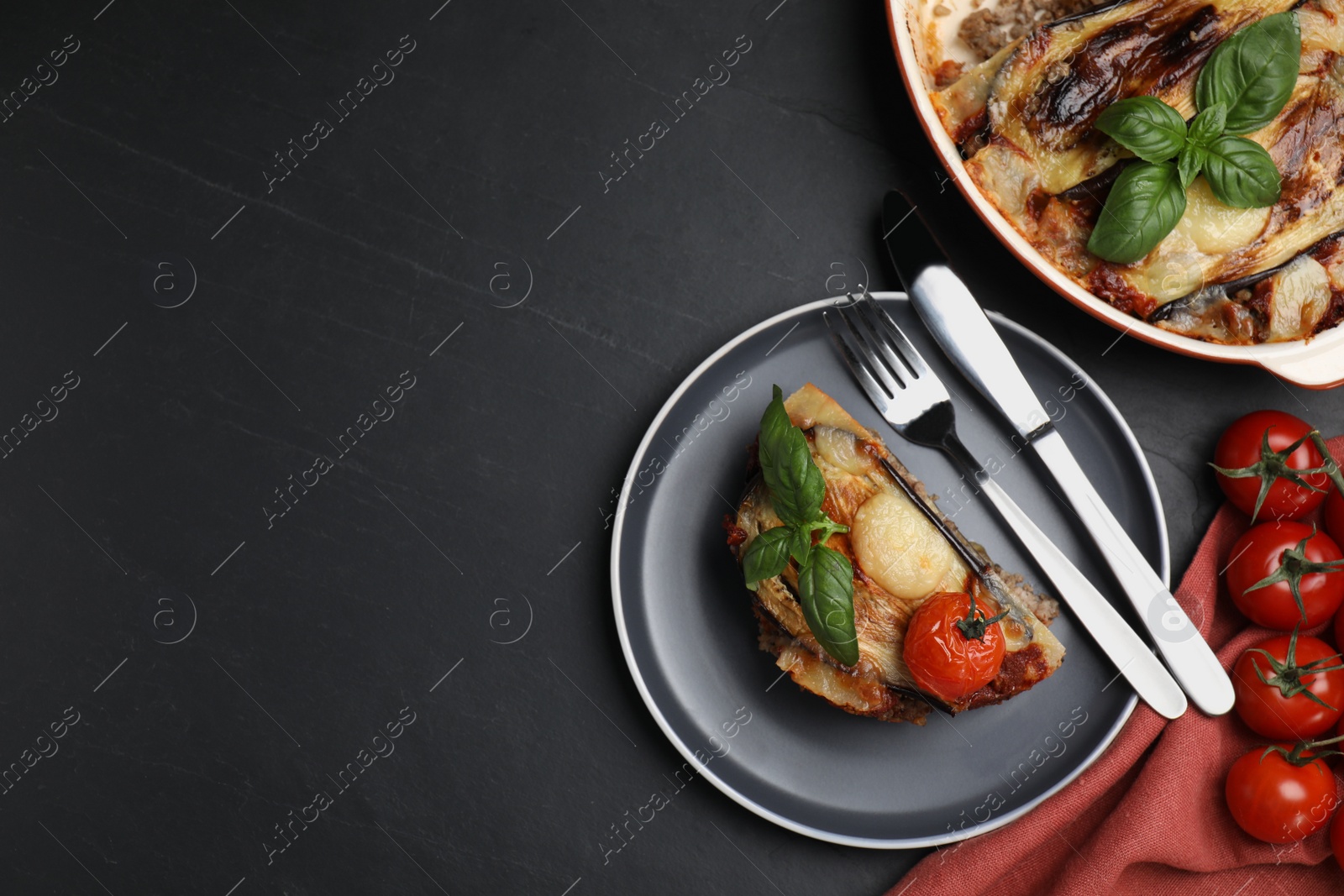 Photo of Plate of delicious eggplant lasagna served on black table, flat lay. Space for text