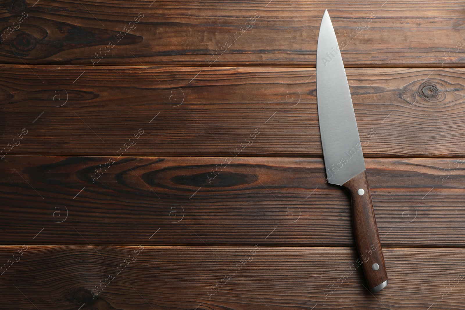 Photo of One knife on wooden table, top view. Space for text