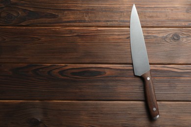 Photo of One knife on wooden table, top view. Space for text