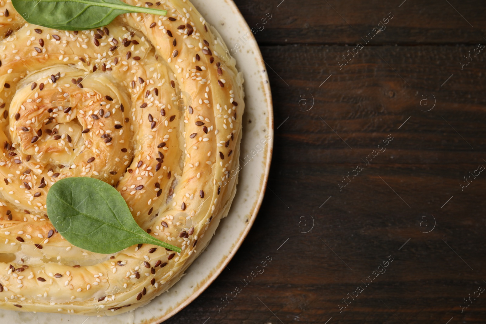 Photo of Delicious puff pastry with spinach on wooden table, top view. Space for text