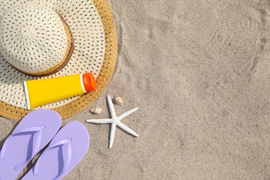 Flat lay composition with bright flip flops on sand. Space for text