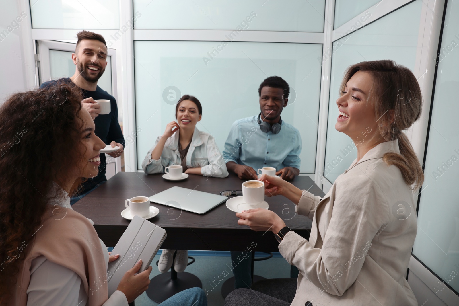 Photo of Team of employees enjoying coffee break together in office. Startup project