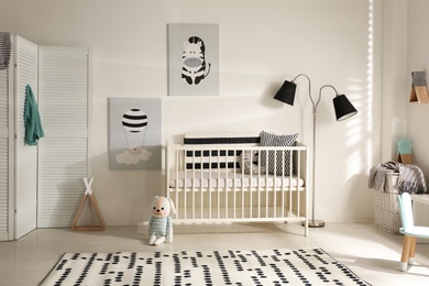 Cute baby room interior with crib and decor elements