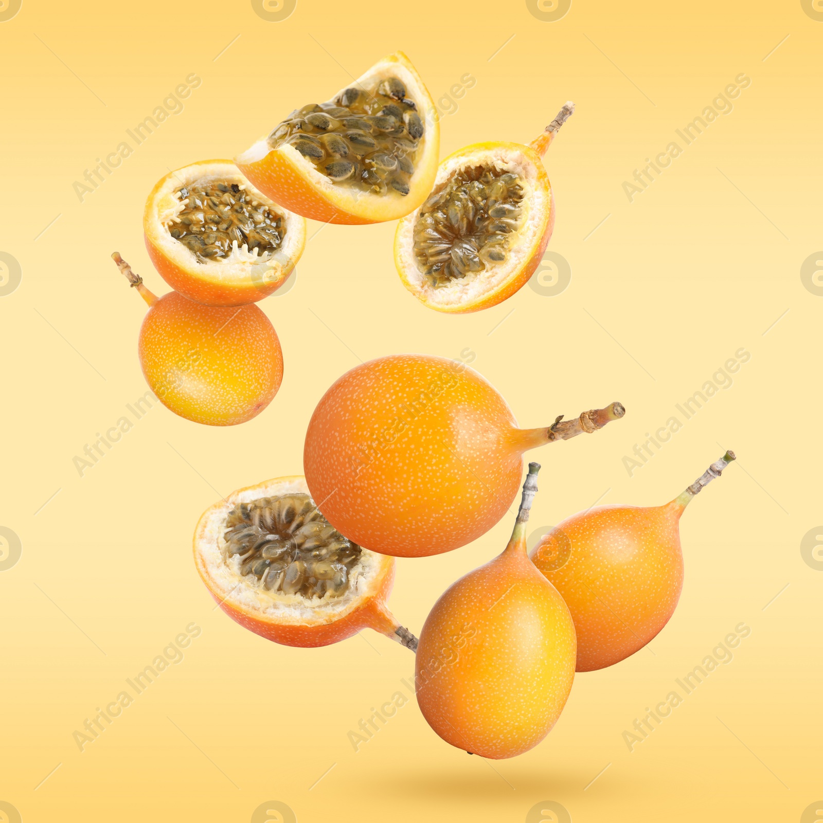 Image of Delicious ripe granadillas falling on orange background