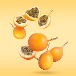 Delicious ripe granadillas falling on orange background