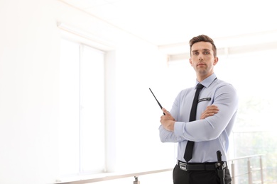 Photo of Male security guard with portable radio transmitter indoors