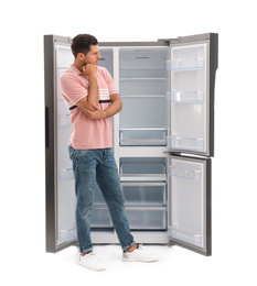 Man near empty refrigerator on white background
