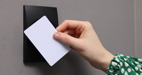 Photo of Woman opening magnetic door lock with key card, closeup. Home security