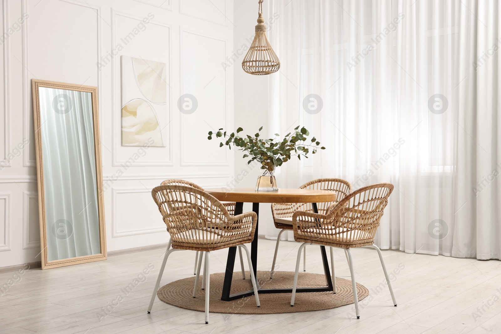 Photo of Dining room interior with comfortable furniture and eucalyptus branches