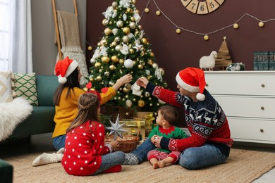 Photo of Family decorating beautiful Christmas tree at home