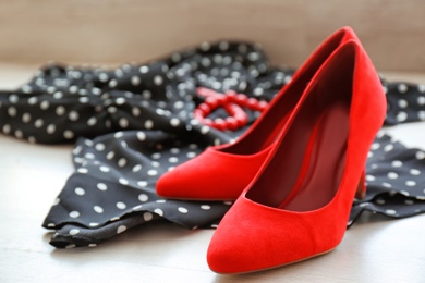 Photo of Elegant female shoes and dress on wooden floor, closeup