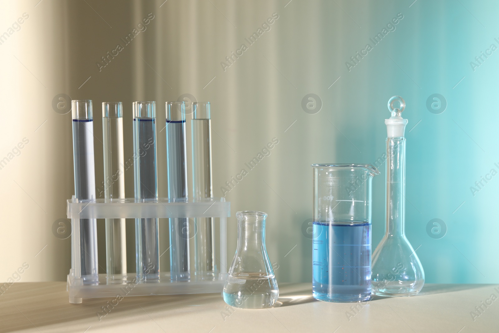 Photo of Laboratory analysis. Different glassware on table against color background