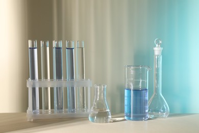 Photo of Laboratory analysis. Different glassware on table against color background