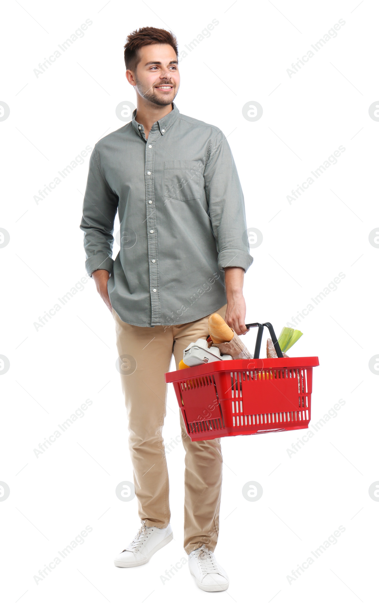 Photo of Young man with shopping basket full of products isolated on white