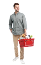 Photo of Young man with shopping basket full of products isolated on white