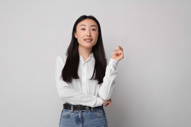 Portrait of smiling woman on light background