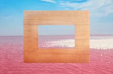 Image of Wooden frame and beautiful pink lake under blue sky with clouds