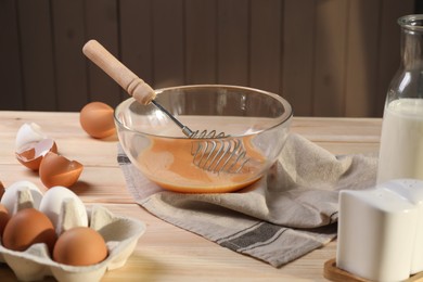 Making dough. Beaten eggs in bowl on wooden table