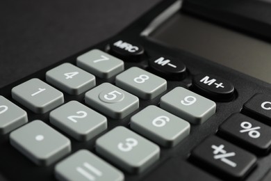 Photo of Calculator on black background, closeup. Office stationery