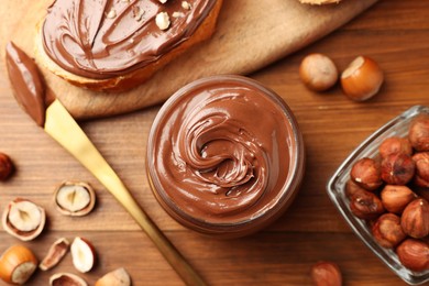 Flat lay composition with tasty chocolate hazelnut spread on wooden table