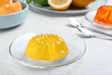 Photo of Delicious fresh yellow jelly on white wooden table