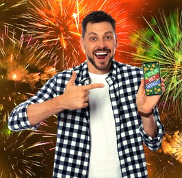 Image of Your Bet Wins! Happy man pointing at smartphone against background with fireworks