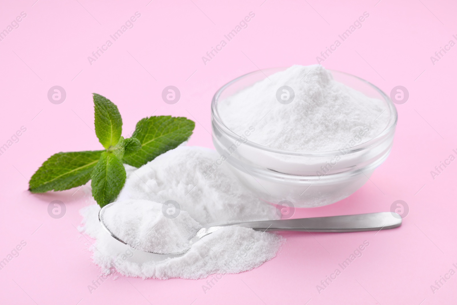 Photo of Sweet powdered fructose and mint leaves on pink background