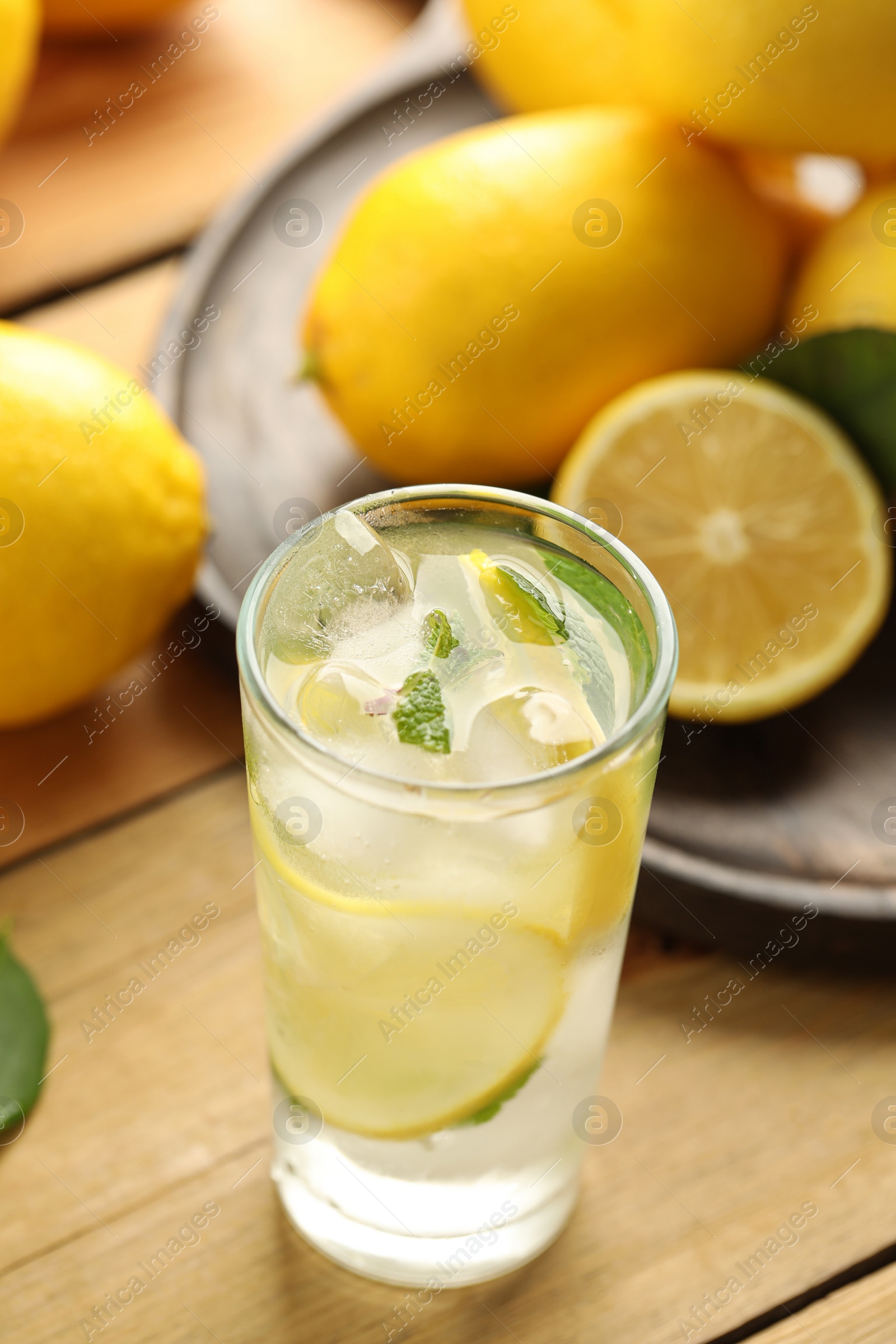 Photo of Cool freshly made lemonade and fruits on wooden table