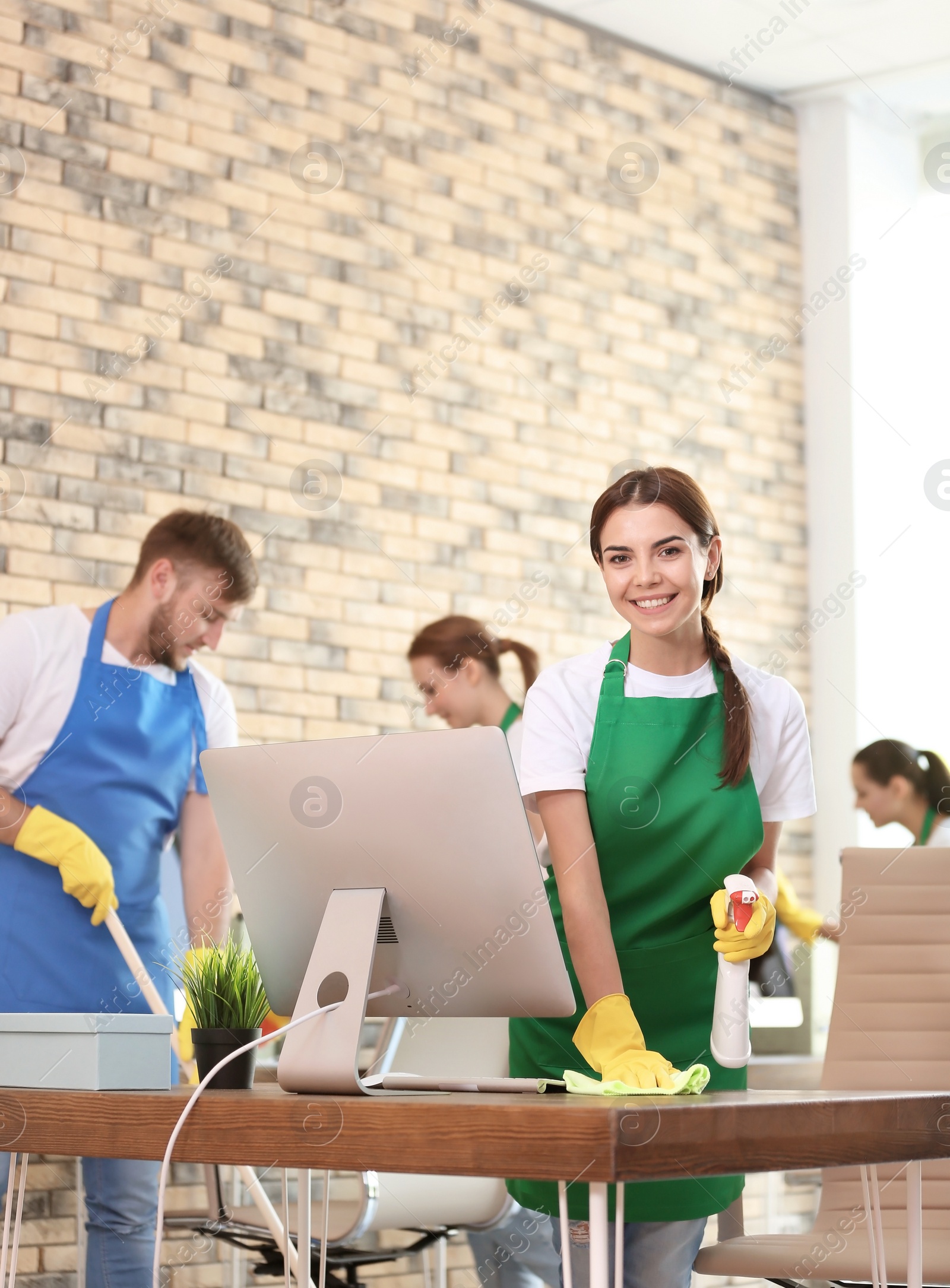 Photo of Team of professional janitors in uniform cleaning office