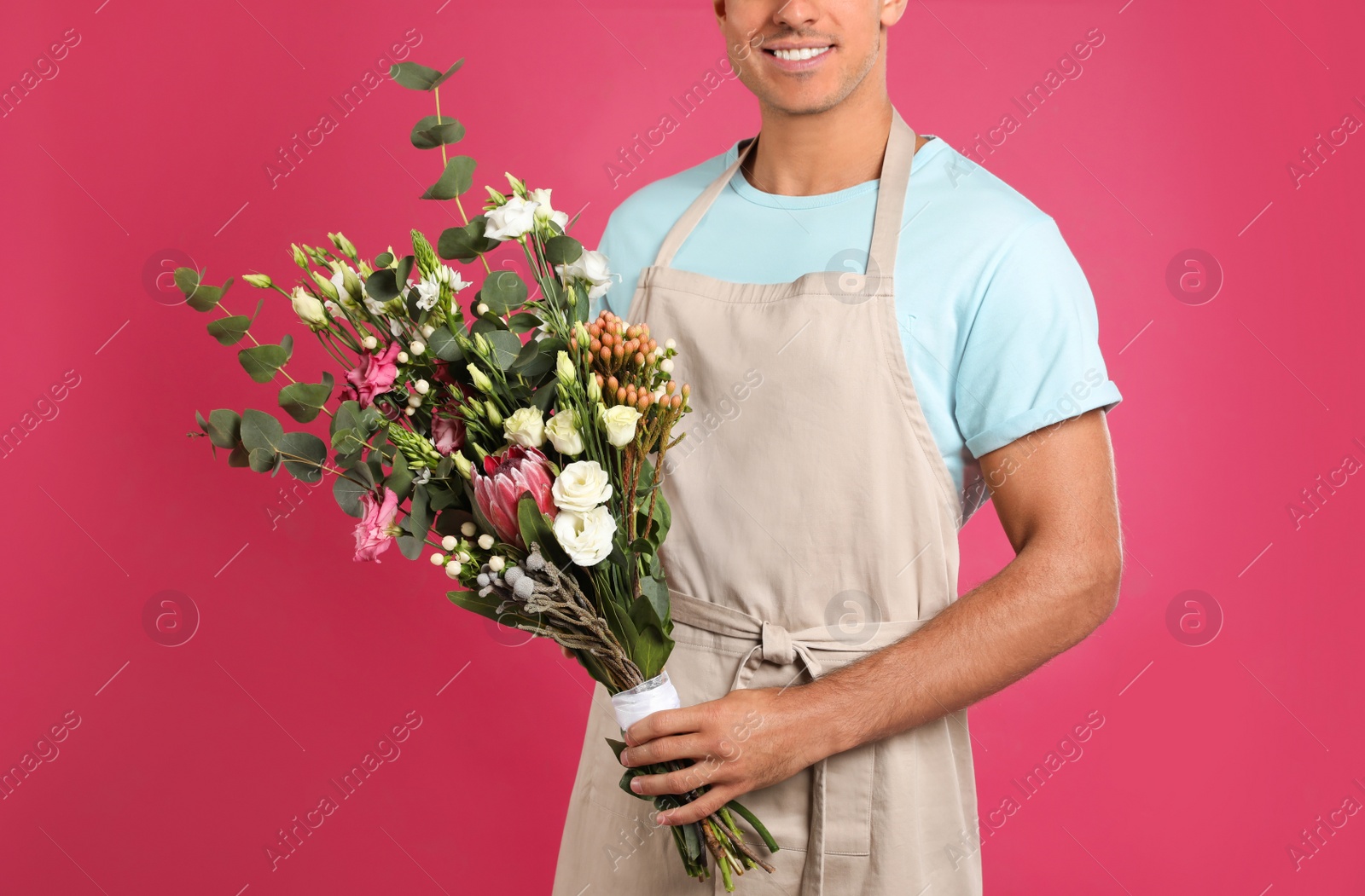 Photo of Florist with beautiful bouquet on pink background, closeup