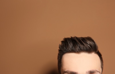 Young man with hair loss problem on color background