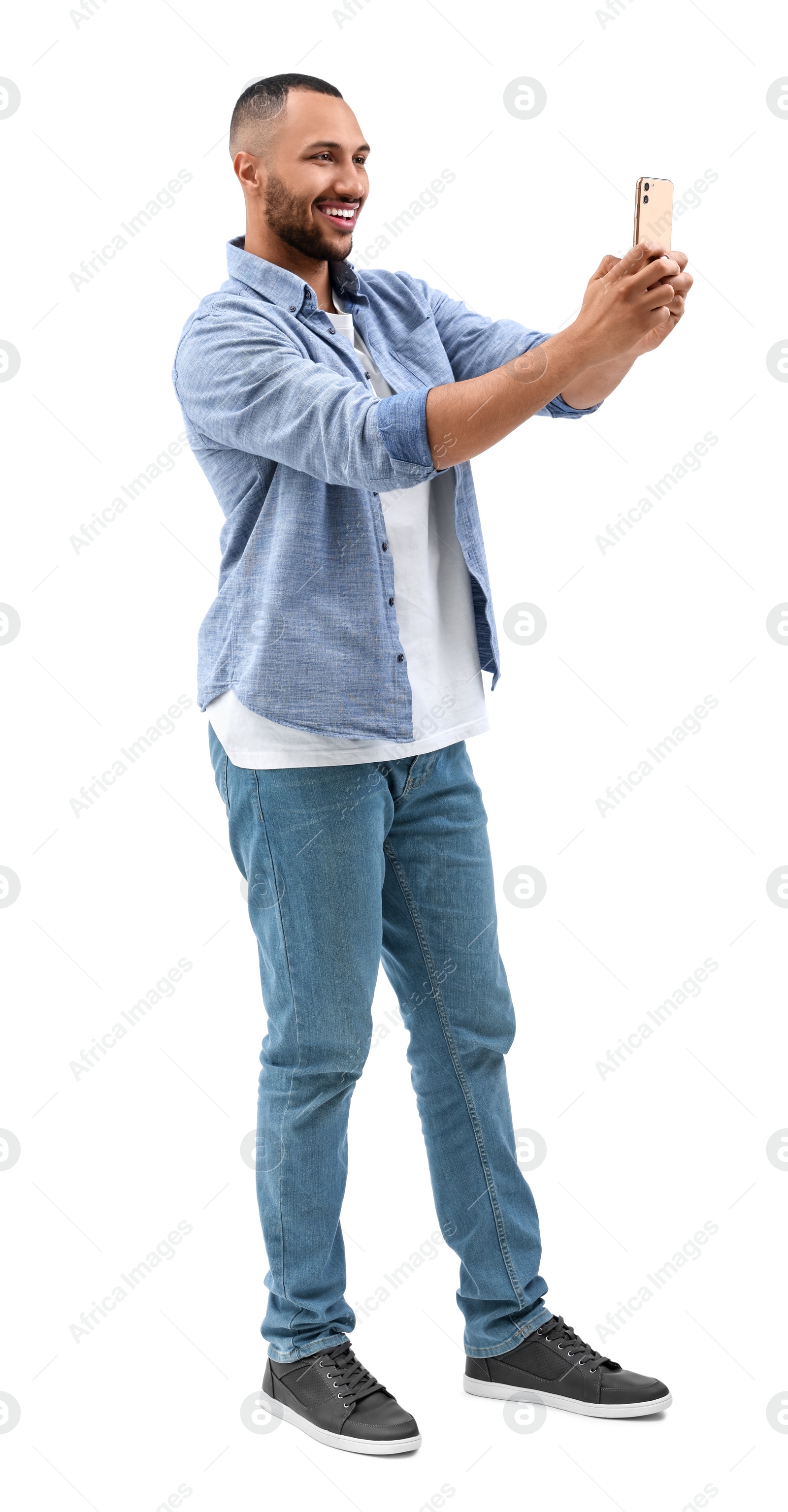 Photo of Smiling young man taking selfie with smartphone on white background