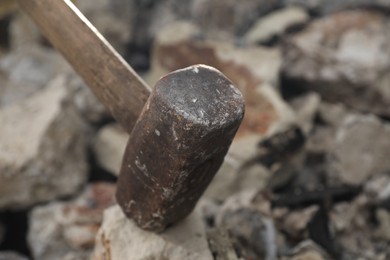 Photo of Breaking stones with metal sledgehammer outdoors, closeup