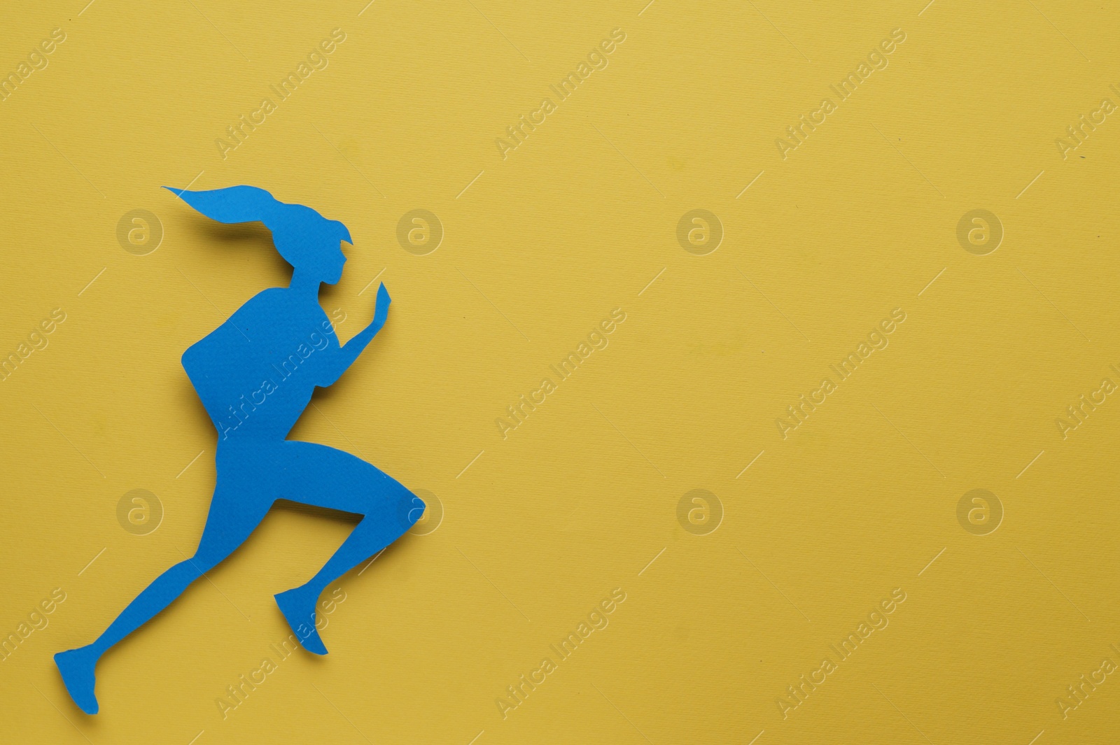 Photo of Sportswoman paper figure on yellow background, top view with space for text. Woman`s health