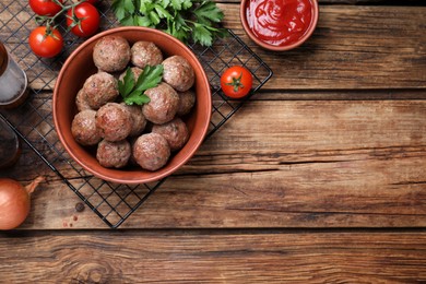 Tasty cooked meatballs with parsley on wooden table, flat lay. Space for text