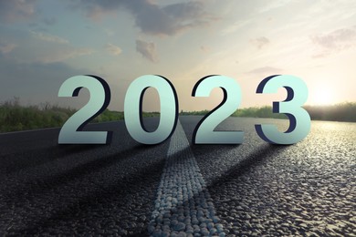 Image of Start of new 2023 year. Numbers on asphalt road during sunrise