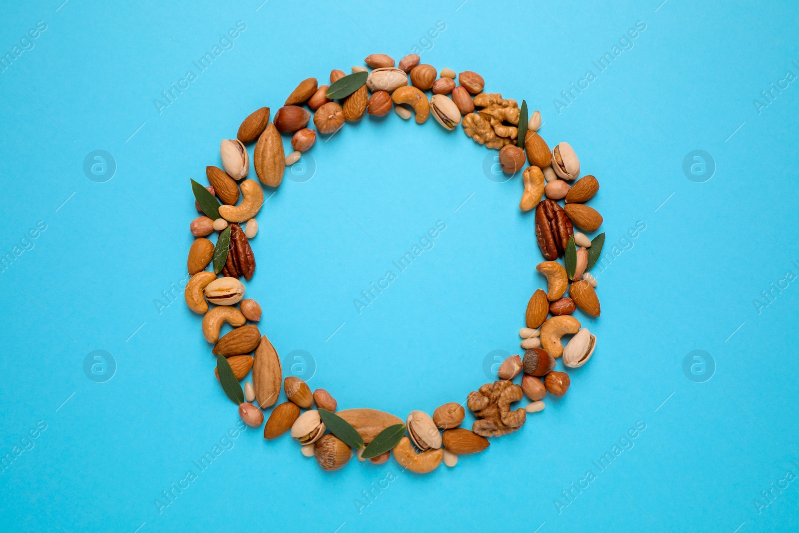 Photo of Different delicious nuts on light blue background, flat lay. Space for text