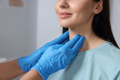 Endocrinologist examining thyroid gland of patient indoors, closeup